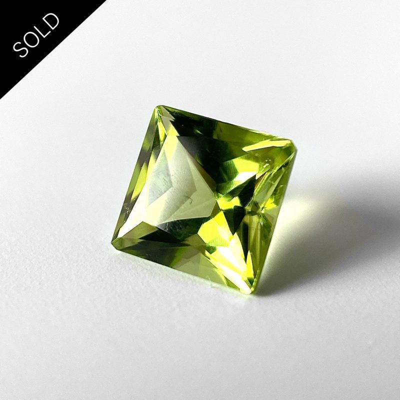 Dieser grüne Edelstein im Carre-Schliff wird Oliven oder Peridot genannt.