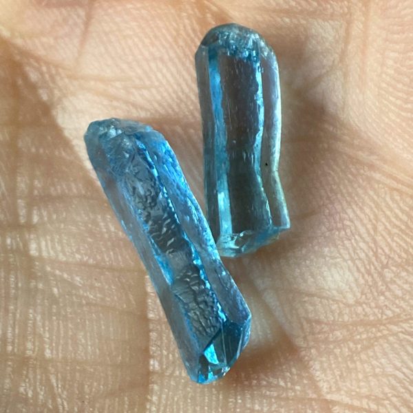 Himmelblaues Aquamarin Paar in Natur-Form und Natur-Schliff. Die 2 Edelsteine aus der Beryll-Gruppe haben unterschiedliche Längen und besitzen kleine Einschlüsse.