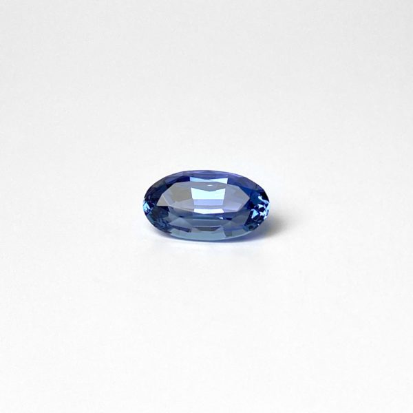 Ovaler Blau/Violetter transparenter und unbehandelter Tansanit in Scheren schliff. Der aus der Zoisit-Gruppe stammende Edelstein ist unbehandelt. Die Farbe des Steines harmonisiert zu einem warmen Goldton.