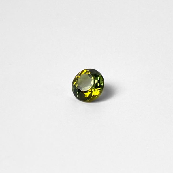 Dieser runde Edelstein ist ein grün gelber Turmalin im modifiziertem Brillantschliff.
