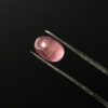 Der rosafarbene ovale Turmalin in cabochon schliff, besitzt kleine einzigartige Einschlüsse, die bei genauer Betrachtung sichtbar sind. Bei Lichtreflexion kommt der Katzenauge-Effekt zum Vorschein.