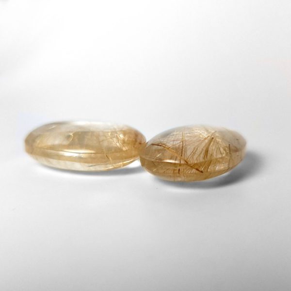 Dieser Rutilquarz ist ein Edelstein ovaler cabochon mit nadeligen goldenen Einschlüssen.